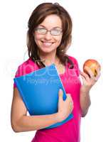 Young student girl is holding book and apple