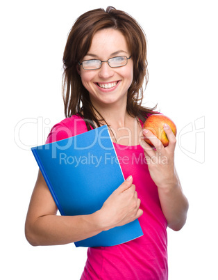 Young student girl is holding book and apple