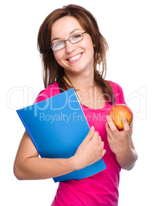 Young student girl is holding book and apple