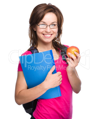 Young student girl is holding book and apple