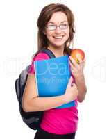 Young student girl is holding book and apple