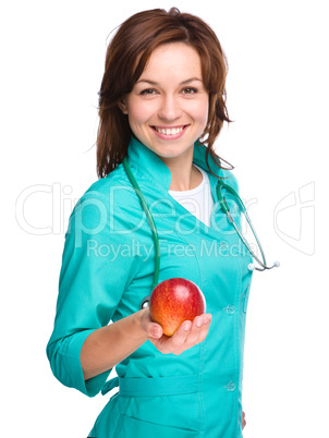 Young lady doctor is holding a red apple