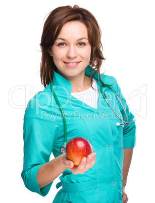 Young lady doctor is holding a red apple