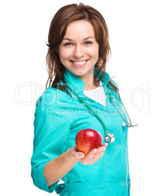 Young lady doctor is holding a red apple