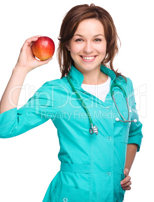 Young lady doctor is holding a red apple