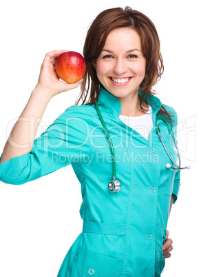 Young lady doctor is holding a red apple