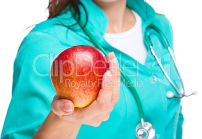 Lady doctor is holding a red apple