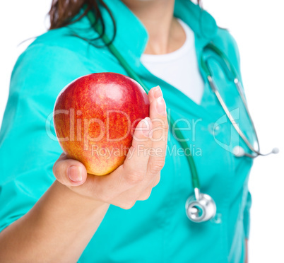 Lady doctor is holding a red apple