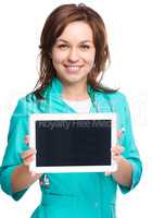 Young cheerful doctor is showing her blank tablet