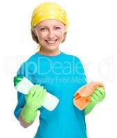 Young woman with cleaning liquid and rag