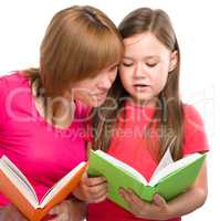 Mother and her daughter are reading books