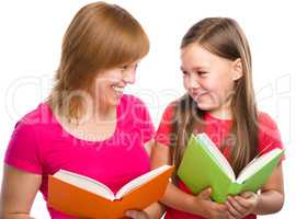 Mother and her daughter are reading books