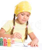 Cute thoughtful child play with paints
