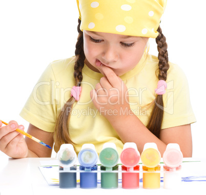 Cute thoughtful child play with paints