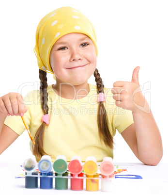 Cute cheerful child play with paints