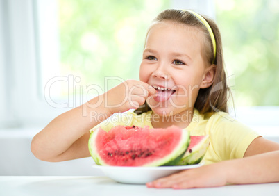 Cute little girl is eating watermelon