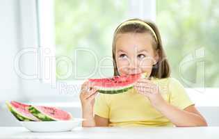 Cute little girl is eating watermelon