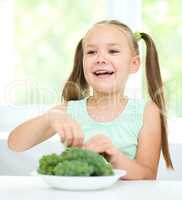 Cute little girl is eating green grapes