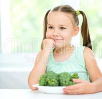 Cute little girl is eating green grapes