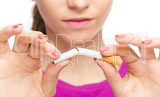 Young woman is breaking a cigarette