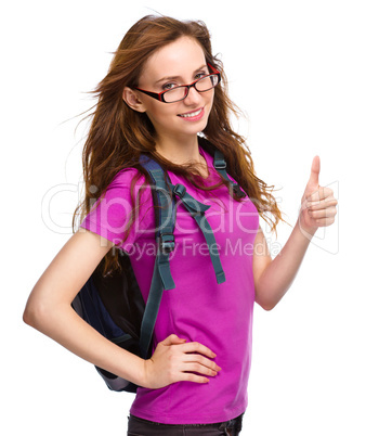 Young student girl is showing thumb up sign