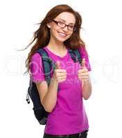 Young student girl is showing thumb up sign