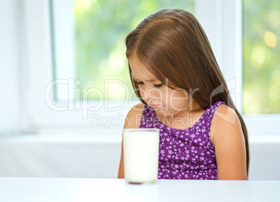 Sad little girl with a glass of milk