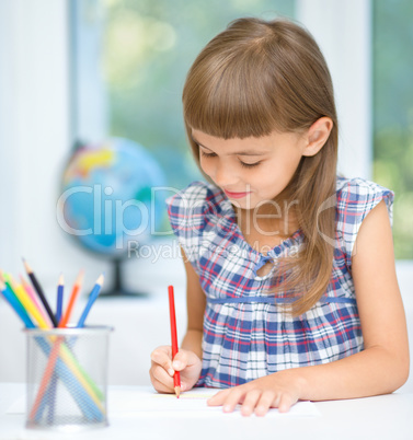 Little girl is drawing using pencils