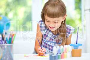 Little girl is painting with gouache