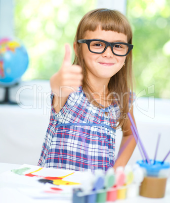 Little girl is painting with gouache