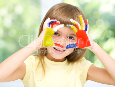 Portrait of a cute girl playing with paints