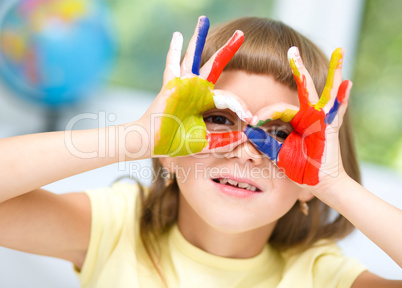 Portrait of a cute girl playing with paints