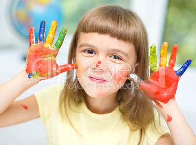 Portrait of a cute girl playing with paints