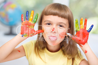 Portrait of a cute girl playing with paints