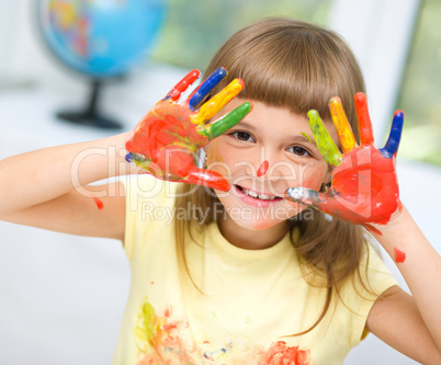 Portrait of a cute girl playing with paints