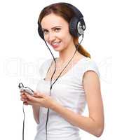 Young woman enjoying music using headphones