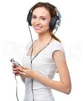 Young woman enjoying music using headphones