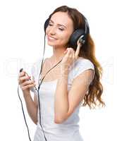 Young woman enjoying music using headphones