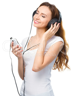 Young woman enjoying music using headphones