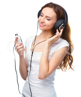 Young woman enjoying music using headphones