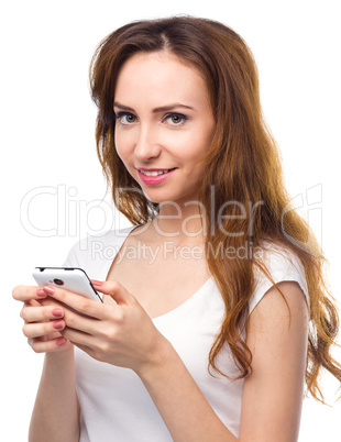 Young woman is typing sms message on her phone