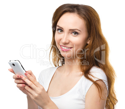Young woman is typing sms message on her phone