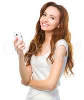 Young woman is typing sms message on her phone