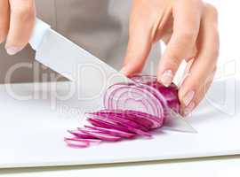 Cook is chopping onion