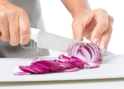 Cook is chopping onion