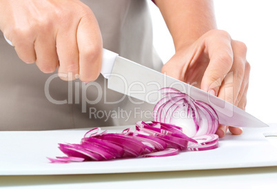 Cook is chopping onion