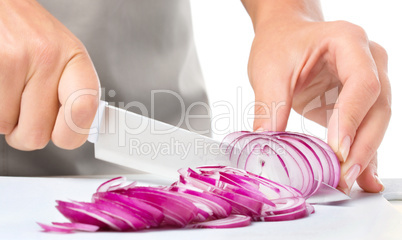 Cook is chopping onion