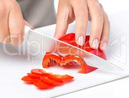 Cook is chopping bell pepper