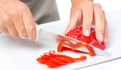 Cook is chopping bell pepper