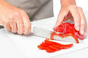 Cook is chopping bell pepper